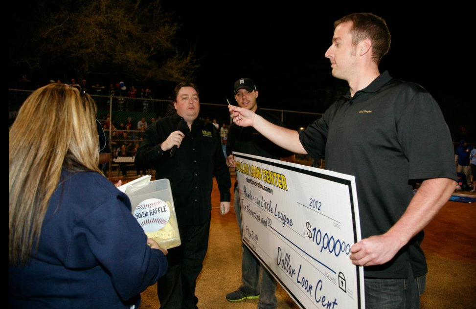 Chuck Brennan of Dollar Loan Center presenting a $10,000 check to the Henderson Little League